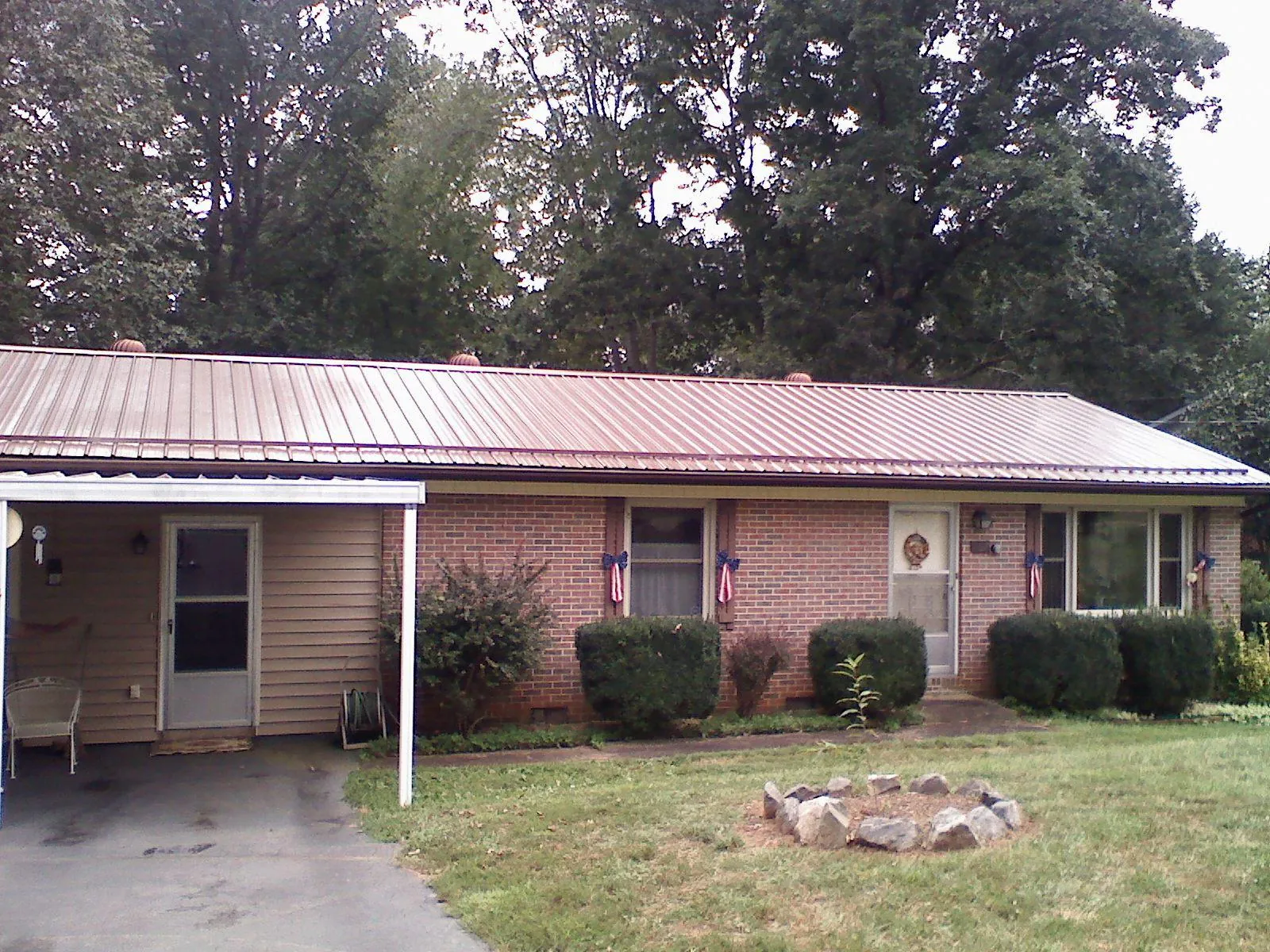 Bronze metal roof and carport on a brick ranch home — Roof Repair work by our crew in Collinsville
